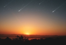 Experience the awe-inspiring beauty of a sunrise with shooting stars across a clear sky, perfect for serene landscapes.